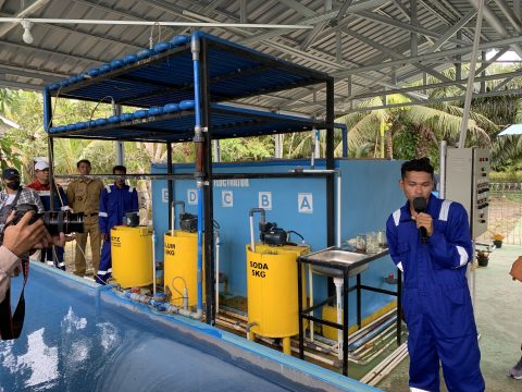 Salah seorang anggota Kelompok Tirta Muda memperlihatkan air olahan yang siap dikonsumsi. (Foto: Lili Hermawan)